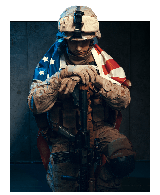 US marine in combat gear holding rifle with American flag, portrait on dark background