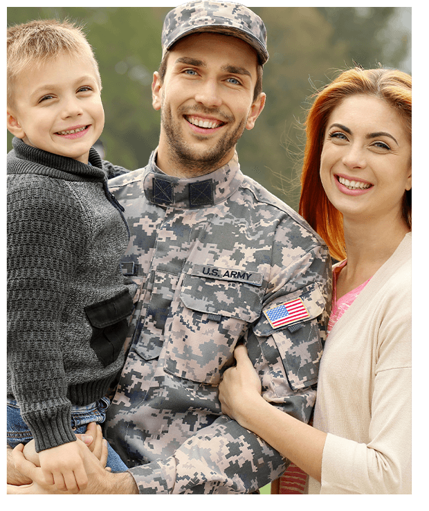 Smiling military family portrait outside - soldier in camouflage uniform with wife and young son